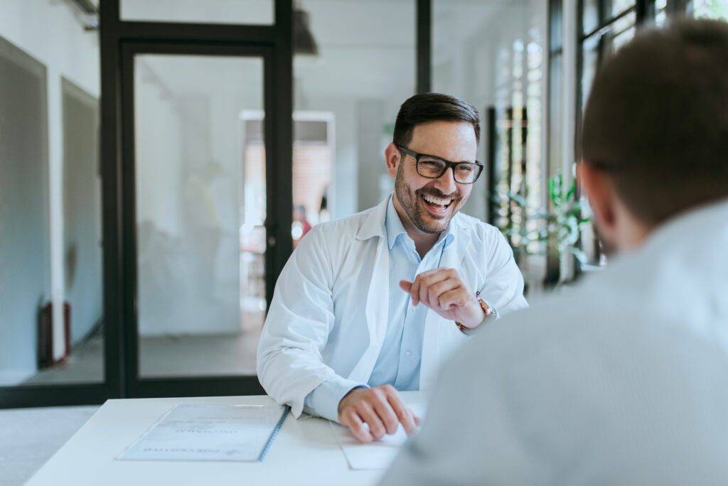 Smiling doctor talking with patient about insurance.